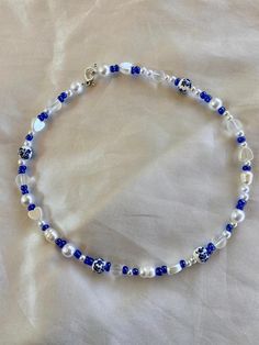 This beautiful blue beaded necklace is made with a variety of different types beads! No specific pattern so each necklace is different! This necklace is 15 inches long! Happy shopping Handmade Blue Round Beaded Pearl Necklace, Handmade Blue Pearl Necklace With Round Beads, Blue Bohemian Pearl Necklace For Gift, Blue Beaded Pearl Necklace With Round Beads, Blue Pearl Necklace With Colorful Beads For Gift, Blue Pearl Necklace With Tiny Beads For Gift, Blue Pearl Necklace With Tiny Beads As Gift, Blue Pearl Necklace With Beaded Chain, Bohemian Blue Heart Beads