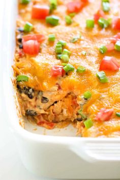 a casserole dish with meat, cheese and veggies in it on a white surface