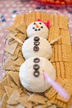 three snowmen made out of crackers sitting on top of a table