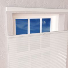 an open window with white blinds and blue sky reflected in the window sill behind it