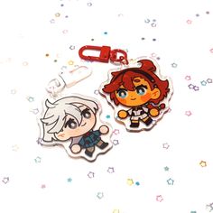 two keychais with cartoon characters on them, one is white and the other is red