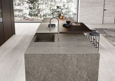 a modern kitchen with granite counter tops and an island style sink in the foreground