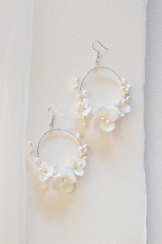 The Flora Hoops have a modern look with the aura of an heirloom. These romantic circular hoop earrings are feminine, yet bold. Decorated with light ivory ceramic blossoms and natural freshwater pearls, the Flora Earrings would be a stunning compliment to any bridal look. Details: Available finishes: gold/ Light Ivory or silver/ light ivory Ceramic Blossom color: light ivory Gold/ Silver Plated jewelry wire Attached to gold/ silver plated ear wire hooks Dimensions: 2.25x3 inches Final Sale Jay Kay, Bridal Earrings Pearl, Light Ivory, Silver Lights, Jewelry Wire, Bridal Look, Gold Light, Silver Plated Jewelry, Floral Bridal