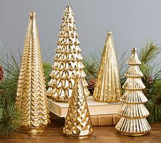 gold christmas trees sitting on top of a wooden table