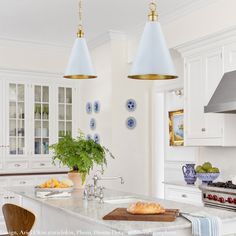 a kitchen with two hanging lights over the island