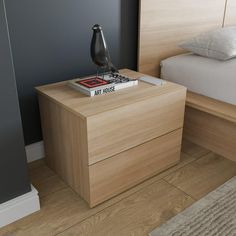 a nightstand with a book on it next to a bed