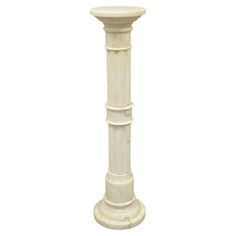 a tall white pedestal with a marble top