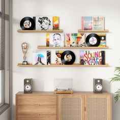 an entertainment center with record players and records on the wall