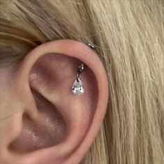 a woman's ear is shown with a single diamond