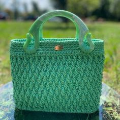 A green jewel that shines your style.With its ideal size,  "Esmeralda" provides ample space for your essentials, making it a safe choice for women seeking both style and functionality! Esmeralda is a crochet bag in green, featuring textured filaments that add a unique touch to its artisanal beauty.  Its resin handles are particularly distinctive, while the inner lining boasts a green patterned fabric that adds a lively flair. T he rigid green faux leather bottom provides structure to the bag. Me Green Beach Bag With Detachable Handle, Green Shoulder Bag With Detachable Handle For Beach, Green Crochet Bag For Gift, Green Handheld Crochet Bag For Summer, Green Handheld Crochet Bag For Beach, Handmade Green Shoulder Bag For Beach, Green Handheld Bags With Braided Handles, Elegant Green Beach Bag, Green Square Crochet Bag As Gift