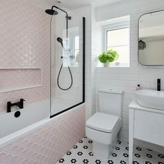 a bathroom with pink and white tiles on the walls, floor, and bathtub