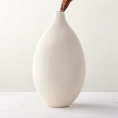 Rounded vase is crafted of clay for an organic sensibility. Warm white vessel is glazed by hand to highlight the striking tonal variations and texture of the finish. A distinctive accent on its own or for showcasing dried botanicals. CB2 exclusive.  -Handmade -Earthenware with white glaze -Pieces will vary in glaze coloring and tone -Decorative use only; not watertight -Wipe with a soft cloth -Botanicals not included -Made in Portugal Haute Warm White Ceramic Vase Tall White Home Decor Ideas, Tall White Vase, Spruce Essential Oil, Wood Pillar Candle Holders, Black Taper Candles, Black And White Vase, Rectangular Vase, Modern Home Accessories, Vase Tall