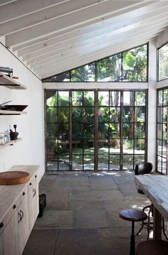 an open kitchen with lots of windows and wooden counter top space in front of the sliding glass doors