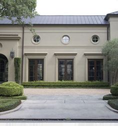 a large house with hedges in front of it