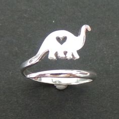 a silver dinosaur ring with a heart on it