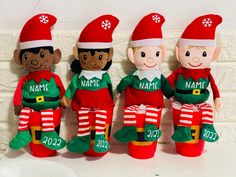 three elf stuffed toys with names and numbers on their legs, one for the boy