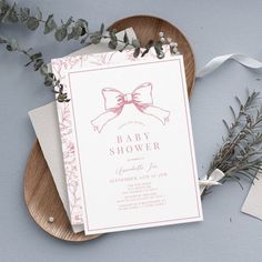 a baby shower is displayed on a plate next to some greenery and ribbon tied around it