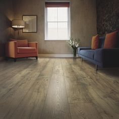 a living room with wood flooring and a couch in the corner next to a window