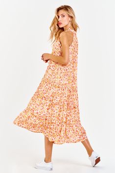 Multi-tiered skirt midi dress, v-neck finished sleeveless with neck ruffle & tassles in contemporary floral print. Blooming floral showcasing life's optimism, always rosy & just cheered! Multi print woven on relaxed fit.Body length from HPS: 46", Sleeve lenght: N/A, Bust: 42" (Size Small) 100% RAYON Machine wash cold, Line dry Imported Spring Pink V-neck Tiered Dress, Pink Flowy Sleeveless V-neck Dress, Pink V-neck Tiered Summer Dress, Feminine V-neck Tiered Summer Dress, Pink Tiered Maxi Dress For Summer, Pink Tiered Skirt Maxi Dress For Summer, Pink Feminine Tiered Beach Dress, Feminine Pink Tiered Vacation Dress, Feminine Pink Tiered Dress For Vacation