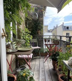 an outdoor patio with potted plants and chairs on the deck, next to a balcony