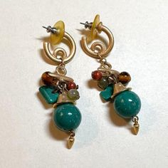 A pair of versatile and wearable vintage hoop earrings with dangles, circa 1980s-90s. Each earring is about 2 1/2 inches total length.  Brushed goldtone metal hoops are about 1/2 of an inch in diameter.  Faux stone round beads and chips, with goldtone bead cap and little dangle on the bottom.  These are posts, and they have their original backs.  Lightweight, because of the faux stones.  No stamps or marks.  Good vintage condition, with some surface wear.  You might want to put new backs on these.   Please clean before wearing! You can find more vintage earrings here: https://www.etsy.com/shop/OtterCatHaus?ref=seller-platform-mcnav&section_id=17074041 Please convo with any questions.  I combine shipping and refund overages of more than fifty cents.  Thanks for visiting my shop today! Earthy Metal Dangle Earrings, Green Metal Clip-on Earrings, Green Metal Dangle Hoop Earrings, Green Dangle Metal Hoop Earrings, Green Dangle Hoop Earrings In Metal, Green Dangle Hoop Earrings, Bohemian Clip-on Metal Earrings, Green Dangle Earrings Costume Jewelry, Green Dangle Costume Jewelry Earrings