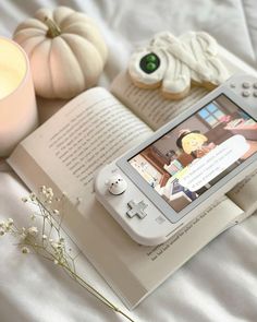 an open book sitting on top of a bed next to a nintendo wii game system