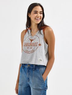 Discover your new go-to for every game in the Women’s Wrangler® Collegiate Vintage Muscle Tee. This vintage-inspired sleeveless muscle tank delivers the school spirit you want, with a distressed print of your team's logo, name, and founding date across the front. It’s crafted from a comfortable cotton blend, complete with a raw edge hem, a cropped length, and your team’s color at the shoulders. This graphic tank will quickly become your go-to for game day. Sleeveless Graphic Print Top For College, Collegiate Sleeveless Top For Streetwear, Collegiate Graphic Print Tops For Summer, Sleeveless Top For Game Day In Spring, Sleeveless Tops For Game Day In Spring, Casual Sleeveless Tank Top For College, Sporty Tank Top For College In Summer, Sleeveless Top For Spring Game Day, Spring Sleeveless Top For Game Day