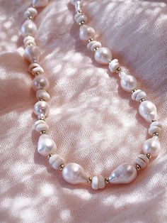 Flanked with luminescent natural white baroque pearls and puka shells, this unique luxurious necklace evokes visions of Hawaii's white sands and soothing shores. Layer this with other beaded beauties and you'll be ready for your tropical escape.✦ DETAILS ✦✧ Name: Kakahi (ka KA hee) - Unique, outstanding, solitary.✧ Adjustable Length✧ White Puka Shells.✧ Genuine Baroque Freshwater Pearls.✧ 14kt Gold Filled with lobster clasp.✧ All Ke Aloha Jewelry pieces come packaged thoughtfully, beautifully, a Handmade White Pearl Shell Necklace, White Shell-shaped Jewelry With Pearl Pendant, White Shell-shaped Pearl Drop Necklace, White Mother Of Pearl Shell Necklace With Pearl Pendant, White Pearl Necklace For Beach, Bohemian White Shell Necklace With Pearl Charm, White Pearl Bohemian Shell Necklace, White Beaded Shell Pearl Necklace, Elegant Pearl Charm Necklace For Beach