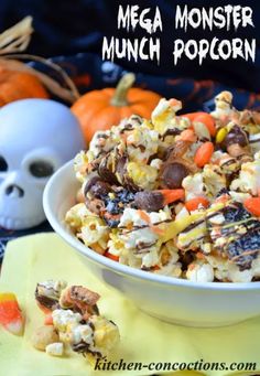 a white bowl filled with halloween popcorn and candy