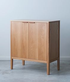 a wooden cabinet sitting on top of a cement floor