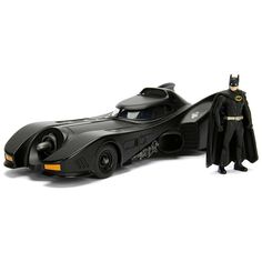 a toy batman car with the batmobile on it's side and an action figure next to it