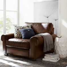 a brown leather chair with pillows on it