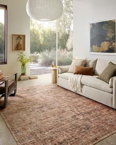 a living room filled with furniture and a large painting hanging on the wall above it