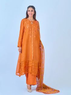 Elegant embroidered cotton net shirt with pants and dupatta a perfect choice for those who appreciate intricate detailing and graceful style. Crafted from high-quality cotton net fabric, this shirt offers a lightweight and luxurious feel, allowing you to feel comfortable and chic throughout the day. The set comes with a matching dupatta and pant which enhances the overall look and adds a touch of finesse to your outfit. Length: 47" Pants Fabric : Raw Silk Dupatta Fabric : Chiffon Designer Orange Sharara With Chikankari Embroidery, Designer Orange Sets With Chikankari Embroidery, Traditional Cotton Silk Wear With Naqshi For Diwali, Traditional Naqshi Cotton Silk Wear For Diwali, Orange Georgette Kurta With Dupatta, Festival Chanderi Kurta With Naqshi, Naqshi Embellished Shantoon Anarkali Set For Wedding, Designer Traditional Wear With Naqshi For Navratri, Festive Cambric Lawn Suit