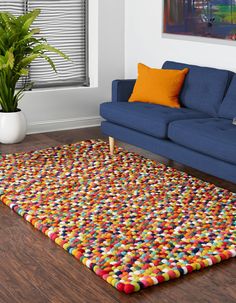 a living room with a blue couch and colorful rug