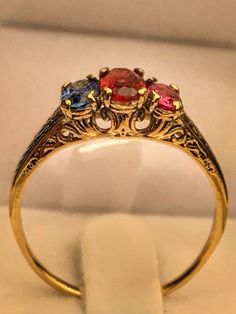 "Very unique handmade gold ring with real gamstones . 14k gold antique victorian ring with a real garnet stones in the middele + 1 real beautiful ruby in the side + one real beautiful sapphire on the other side . Hand made by myself Weight : about 1.9 gram Central stone : garnet 4/6 m\"m Ruby stone : 3/5 mm Sapphire stone : 3/5 mm" Elegant Three Stone Birthstone Ring In 14k Gold, Gold Ruby Rings With Intricate Design, Vintage Garnet Birthstone Ring In Yellow Gold, Victorian Multi-stone Yellow Gold Rings, Vintage Yellow Gold Garnet Birthstone Ring, Vintage Garnet Birthstone Promise Ring, Antique Garnet Promise Ring, Vintage Gold Garnet Birthstone Ring, Vintage Garnet Birthstone Rings