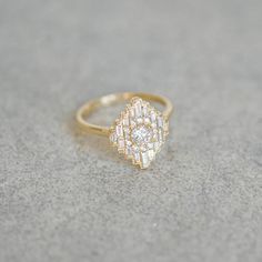 a diamond ring sitting on top of a gray surface