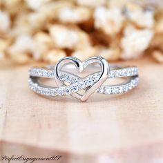 a heart shaped diamond ring on top of a wooden table