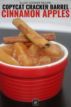 a red bowl filled with cinnamon apples on top of a table