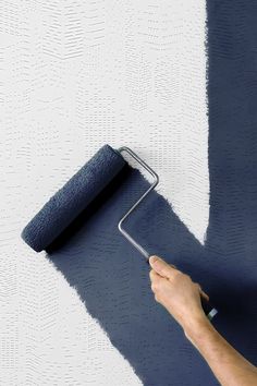 a person using a paint roller on a wall