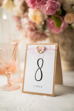 a table number is placed next to some wine glasses