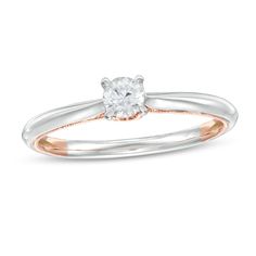 a white and rose gold ring with an oval cut diamond in the center, set on a thin band