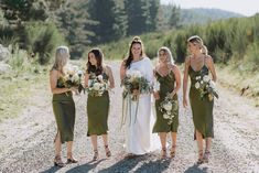 a group of women standing next to each other on a dirt road