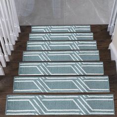 three blue rugs on the steps leading up to a stair case in a house