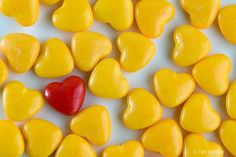 yellow candy hearts with a red heart in the middle