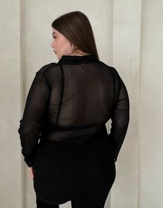 With its sleek and flattering silhouette, the Plus Size Sheer Ribbed Button Up Shirt offers a trending way update to your workwear wardrobe. Wear this plus size sheer top with a cute bralette underneath to give the full effect and a pair of trousers for a street style outfit that's very on trend right now. This top features buttons up the front, long sleeves, a v-shaped neckline, a folded-down collar, and a single chest pocket. The material is a sheer, stretchy knit material. This shirt is made Sheer Long Sleeve Shirt For Work, Sheer Long Sleeve Office Top, Long Sleeve Mesh Top For Work, Long Sleeve Mesh Top For Workwear, Sheer V-neck Blouse For Work, Chic Sheer Button-up Tops, Sheer Button-up Tops For Workwear, Chic Long Sleeve Mesh Top For Work, Sheer Button-up Workwear Tops