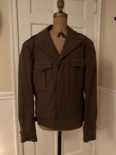 This vintage WWII military Army jacket is made of wool. It is a cropped style with button closure and large front pockets. It has been wonderfully preserved and is a great piece of military memorabilia and US history It is a size 36 R There are no rips, tears or staining Please contact me with any further questions or dimensions Vintage Pea Coat With Pockets For Workwear, Vintage Style Pea Coat With Pockets For Work, Vintage Double-breasted Pea Coat With Pockets, Vintage Khaki Outerwear With Welt Pockets, Brown Military Outerwear With Button Closure, Vintage Long Sleeve Pea Coat With Pockets, Khaki Wool Pea Coat With Pockets, Military Style Collared Utility Jacket Single Breasted, Military Style Collared Utility Jacket