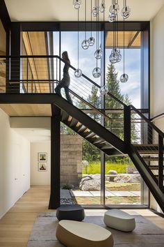 a woman walking up the stairs in a modern house