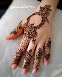 a woman's hand with henna tattoos on it