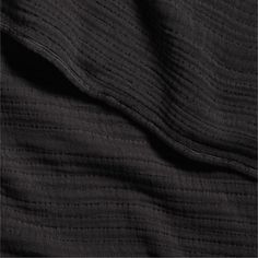 an image of black fabric textured on top of the bedding sheets and pillowcases